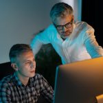 Focused Professionals Collaborating on Computer in Modern Office Setting