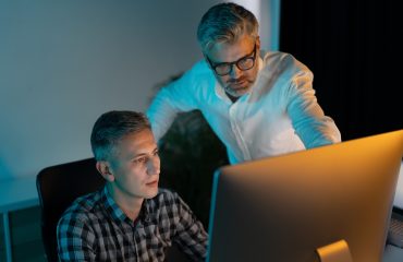 Focused Professionals Collaborating on Computer in Modern Office Setting