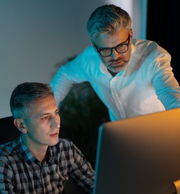Focused Professionals Collaborating on Computer in Modern Office Setting