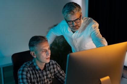 Focused Professionals Collaborating on Computer in Modern Office Setting