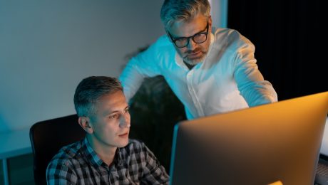 Focused Professionals Collaborating on Computer in Modern Office Setting