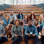 Multiracial group of happy business seminar attendees at convention center looking at camera.