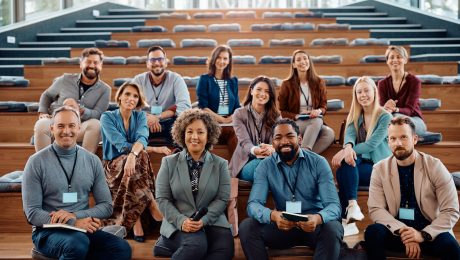 Multiracial group of happy business seminar attendees at convention center looking at camera.